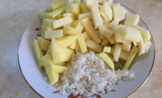 Wash the rice and cut the peeled potatoes into small cubes. Boil the food in a saucepan with water.