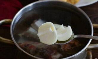 Coupez l'oignon en plusieurs tranches et ajoutez-le au bouillon.