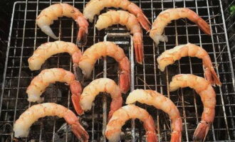 Place a grate on the grill with coals. We distribute langoustines in spices over it.Cook for about 5 minutes over high heat from the fire.