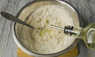 Pour the remaining flour, also sifted, into another container. Pour the dough prepared first into a larger container and add the required amount of vegetable oil. Add flour and salt in several stages. 