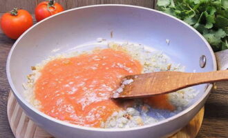 Presiona los tomates y colócalos con las cebollas. Empezar a freír a fuego lento.