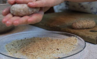 When the specified time has passed, you can begin to form the cutlets. During the sculpting process, each lump of minced meat can also be further compacted by beating it a couple of times with your hand, then the cutlets will be beautiful and even. After shaping, roll each lump of minced meat in breadcrumbs.