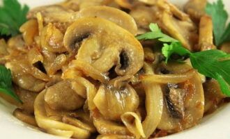 Appetitlich gebratene Champignons mit Zwiebeln sind fertig. Servieren Sie den Leckerbissen zusammen mit einer Beilage auf dem Tisch!