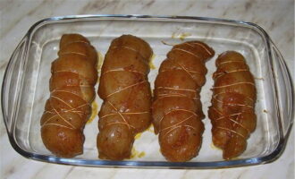 When the breasts are marinated, roll them into rolls and tie them tightly with thread. Place in the refrigerator again for 7-8 hours.