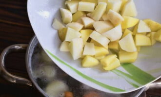 Nous coupons également les pommes de terre en cubes et les combinons avec le bouillon, ajoutons les pois piment de la Jamaïque, les épices pour poisson et laissons cuire 15 minutes.