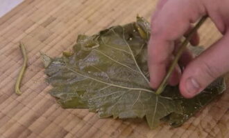 Passem a preparar les fulles de raïm per a la dolma. Assegureu-vos de tallar les tiges, rentar-les bé de la brutícia i omplir-les amb aigua bullida. Deixar reposar 15 minuts.