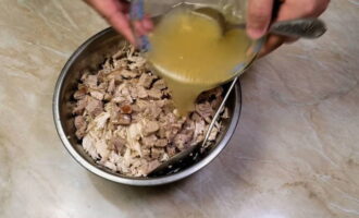 Pour the swollen gelatin into the chopped pieces of meat and mix well.