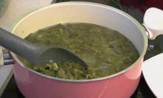 Stirring constantly, blanch the sorrel for no more than a minute. We don't need to boil it. After blanching, the sorrel will change its color from deep green to olive.