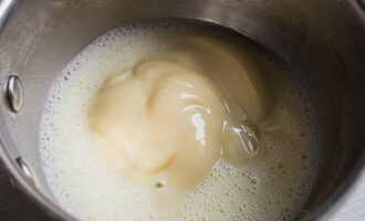 While the biscuit is cooling, prepare the cream. In a small saucepan or saucepan, combine the yolks and water. Add condensed milk and vanilla essence to them and place the dishes on low heat. Stirring constantly, bring the mixture until it thickens: dip the spoon halfway into the liquid and if the trace of it remains for a long time, then the consistency is suitable. 