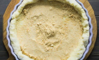 Grease the baking dish with a small amount of oil, roll out the dough into a round layer with some room on the sides, transfer to the pan and press down. Sprinkle the bottom with cookie crumbs.