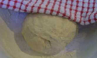 Now we make a ball out of the dough and cover the container on top with a towel. Leave for 2 hours for it to rise.