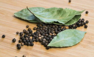 When the broth boils again, add 4 bay leaves, 10 black peppercorns and greens, which must be finely chopped in advance. You can take parsley, which is most suitable for fish soup, or dill. Stir the broth thoroughly again.  