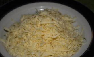 While the cutlets are baking, grate the cheese on a coarse grater. It is better to use soft cheese, as it melts better.