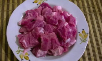 How to cook delicious and juicy minced pork cutlets? Wash the meat, pat dry with paper towels and cut into large cubes. Peel the onion and cut into 4 parts.