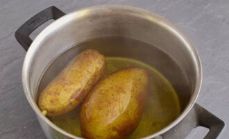 Boil the potatoes in their skins, cool and grate on a medium grater.