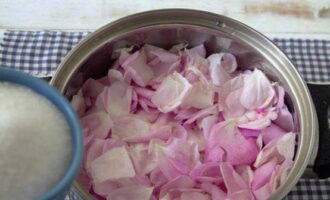 Aboqueu una mica de sucre a la cassola. A continuació, de nou, ¼ dels pètals i una mica de sucre. Continueu fins que us quedeu sense ingredients.