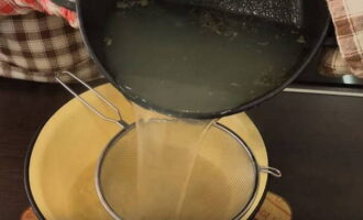 Remove the finished fish from the pan and strain the broth through a sieve. 