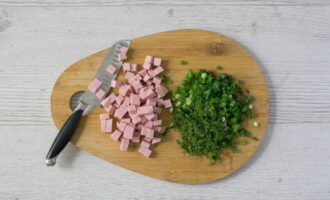 Cut the sausage into cubes. Wash the greens and chop finely with a knife.