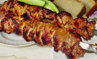 Thread the marinated meat onto skewers and place on the grill. Grill the meat over hot coals, turning occasionally. Make sure there is no open flame and the meat cooks evenly. Serve the finished shish kebab to the table immediately.