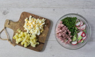 Peel the boiled potatoes and eggs and cut them into cubes.