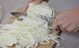 How to prepare juicy and crispy sauerkraut for the winter in jars according to the classic recipe? We cut the cabbage into several parts, and then chop it in any way convenient for you.