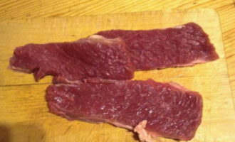 Como preparar estrogonofe de carne com creme de leite segundo a receita clássica? Cortamos todas as películas e veias da carne. Corte em pedaços ao longo das fibras com até 1 cm de espessura.