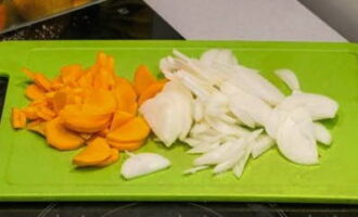 ¿Cómo hacer sopa de puré de calabacín según la receta clásica? Pelar las cebollas y las zanahorias. A continuación, corta las verduras en trozos pequeños.