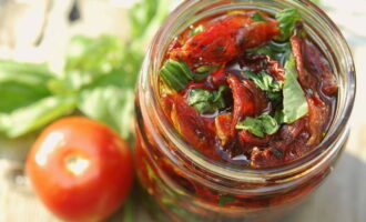 Place the prepared tomatoes in prepared sterilized containers and pour in hot vegetable oil until it completely covers the vegetables. Seal tightly and store in the refrigerator. 