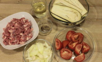 How to cook eggplant moussaka in Greek style with minced meat according to the classic recipe? First, prepare all the ingredients. We thoroughly wash all vegetables and meat. Cut the eggplants into thin slices, cut the tomatoes into slices, and cut the onions into strips. Remove all films from the lamb, cut into small pieces and grind through a meat grinder or grind using a blender.