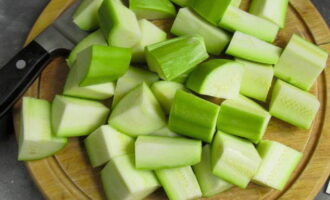 How to cook chicken with zucchini in the oven? Wash the zucchini, peel and cut into large cubes. Place the vegetables in a bowl, add sunflower oil, salt and season.