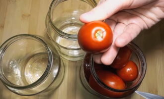 Jars can be either sterilized or simply washed with soda. We pierce the dried tomatoes near the stalk and place them in prepared jars.