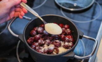 Taburkan ceri yang disediakan dengan gula. Letakkan kuali di atas dapur, biarkan kandungannya mendidih dan masak selama 5 minit lagi. Kacau campuran dengan kerap sehingga produk kering dibubarkan sepenuhnya.