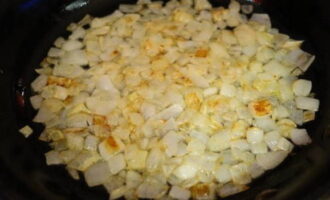 Heat a frying pan over a fire, pour vegetable oil into it and fry the chopped onion. It is necessary to fry over low heat so that the onion does not burn, but becomes transparent with a golden hue.