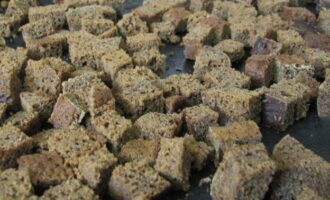 Place the cubes on a baking sheet and place in the oven preheated to 180 °C. The bread should dry out and darken. 