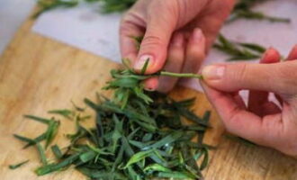 We wash the tarragon branches and remove the leaves. Only they are useful for pickling.