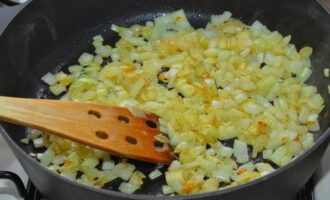 Despeje uma pequena quantidade de óleo na frigideira. Colocamos no fogão e ligamos o equipamento. Aqueça por um minuto. Adicione a cebola e frite por cerca de 2-3 minutos. Mexa constantemente com uma espátula.