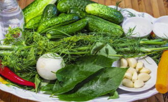 Como preparar pepinos enlatados crocantes para o inverno em potes de 1 litro? Lave os pepinos e as verduras. Descasque o alho e a cebola.