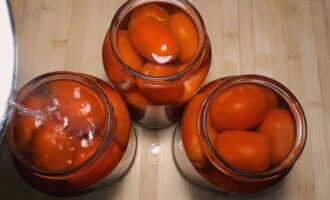 Gradually pour boiling water into the jars and cover with lids. Do not touch the tomatoes for 10-15 minutes.