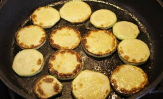 Fry the prepared zucchini in vegetable oil on both sides. Cook until brightly browned.