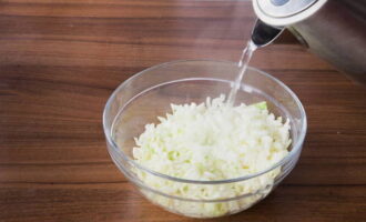 Mettez le chou et les oignons hachés dans un bol et ajoutez de l'eau fraîchement bouillie, puis laissez infuser 10 minutes. Passé ce délai, placez les légumes dans une passoire pour égoutter toute l'eau.