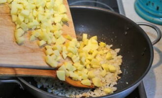 Finely chop the onion and fry it until golden brown in vegetable oil. Next we lay out the potatoes.