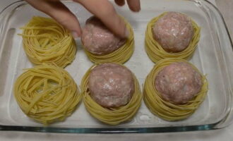 Then place the formed meat balls into the pasta nests. This stage can be called stuffing.