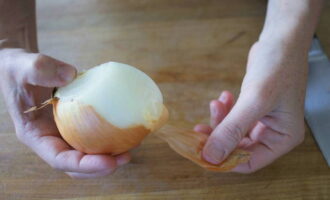 Getting rid of onion skins. To make it easier to chop the onion, first cut it in half. And then each part into small cubes.