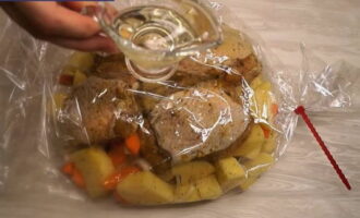 After this time, place the vegetables marinated with meat into the prepared baking sleeve.