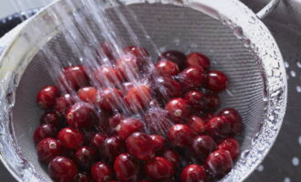 We sort out the cherries. If there are spoiled berries, throw them away. Remove the branches. We use a special device to remove the bones, or do it in another accessible way.