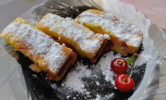 Keluarkan kek panas dari kuali. Hiaskan pencuci mulut dengan gula tepung, bahagikan kepada bahagian dan hidangkan.