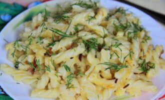 Divide delicious macaroni and cheese into serving bowls. We complement the dish with aromatic chopped herbs and serve! 