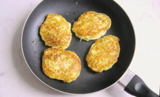 Metti un cucchiaio di impasto di zucchine su una padella calda, formando delle frittelle ordinate. Friggerli a fuoco basso su ciascun lato fino a doratura. Ci vorranno circa 10 minuti.