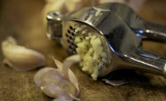 Peel the garlic and chop it using a garlic grinder.