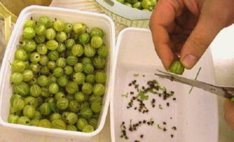 Wie bereitet man pürierte Stachelbeeren ohne Kochen mit Zucker für den Winter zu? Sortieren Sie die Beeren, entfernen Sie verdorbene und reißen Sie die Stiele und Stecklinge vom Rest ab. Es ist bequem, unnötige Teile mit einer Nagelschere zu entfernen, aber diese Arbeit erfordert Geduld und Zeit.